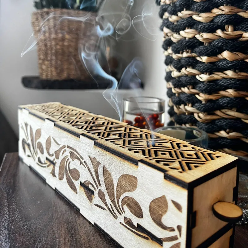 Een handgemaakte wierrookhouder met een brandend wierrookstokje erin