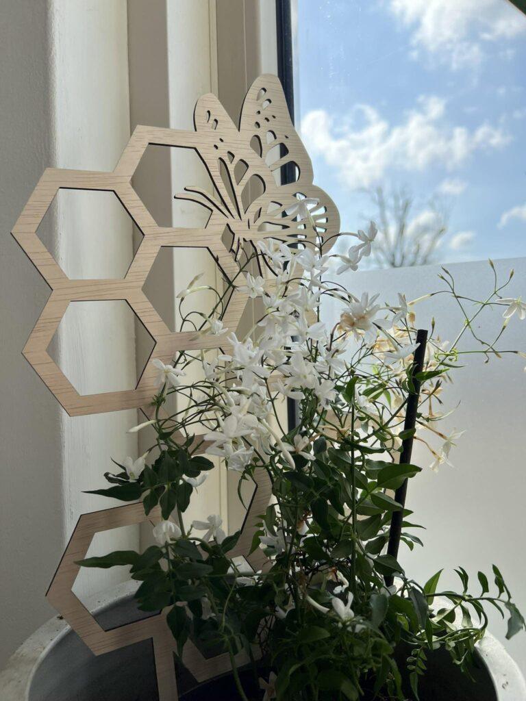 Zelfgemaakt houten klimrek met vlinderpatroon voor ondersteuning van kamerplanten.