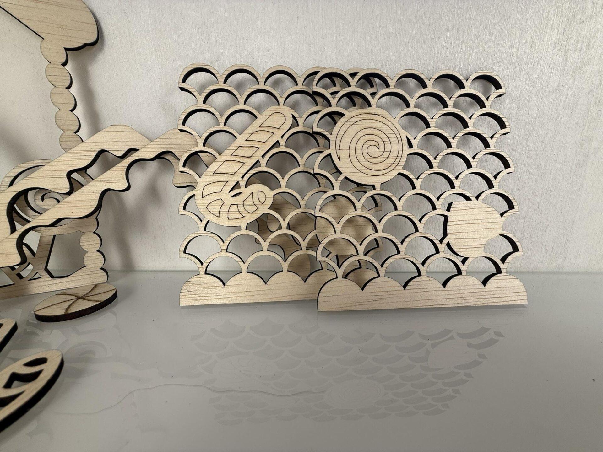Houten decoratieve elementen met een golfpatroon en een spiraalvorm in een lichte afwerking.