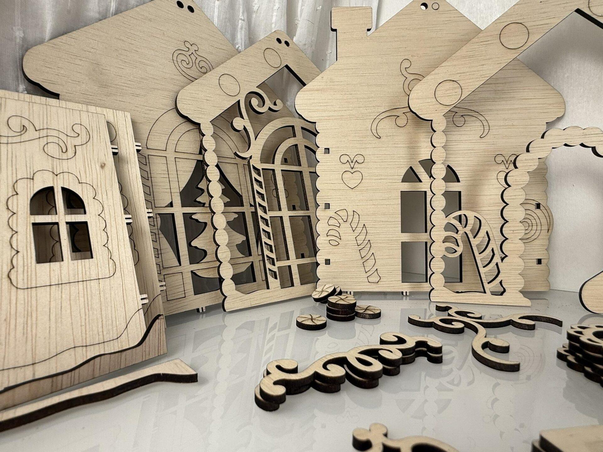 Houten decoratieve huisjes en losse onderdelen op een witte ondergrond.