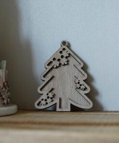 Houten ornament in de vorm van een kerstboom met decoratieve snijwerkdetails.