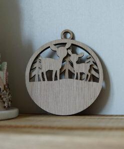 Houten ornament met een ontwerp van herten en bomen, hangend aan een muur.