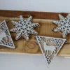 Set van houten kerstdecoraties met sneeuwvlokken en herten in een driehoekige vorm.