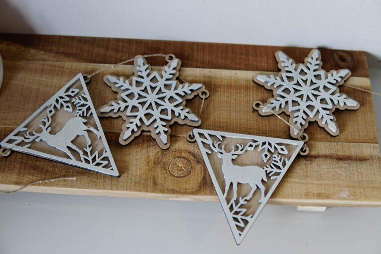Set van houten kerstdecoraties met sneeuwvlokken en herten in een driehoekige vorm.
