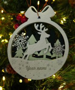 Houten kerstornament met een rendier en sneeuwvlokken in een cirkelvormig ontwerp.