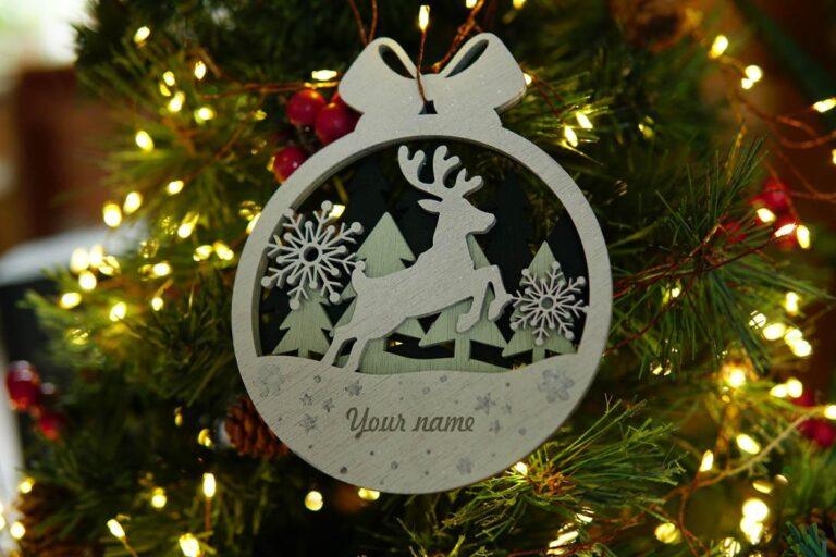 Houten kerstornament met een rendier en sneeuwvlokken in een cirkelvormig ontwerp.