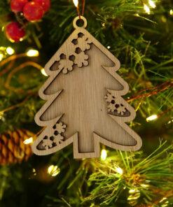 Houten ornament in de vorm van een kerstboom met sneeuwvlokken, hangend aan een dennenboom.