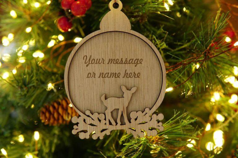 Houten kerstornament met een hert en de tekst 'Your message or name here' in een dennenboom.