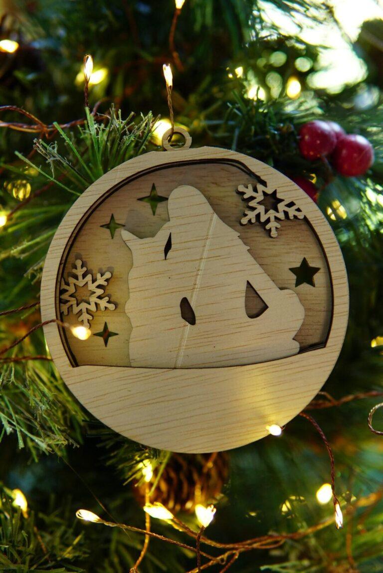 Houten kerstornament met vrouw en hond in wintersilhouet