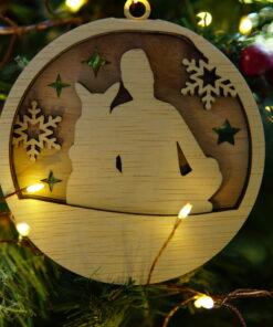 Houten kerstornament met man en hond tussen sneeuwvlokken